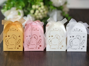 Detail of laser-cut elephant candy boxes with intricate heart patterns and organza ribbons