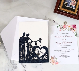 Detail of laser-cut navy blue glitter wedding invitation set with Mr and Mrs silhouette