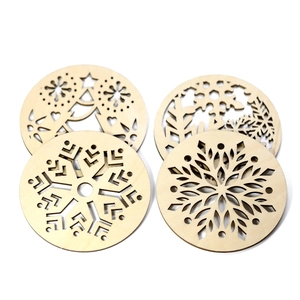 Close-up of laser-cut wooden Christmas coasters with snowflake and tree patterns