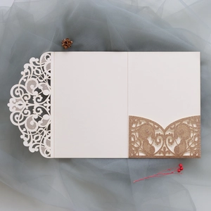 Macro detail of laser-cut invitation sleeve with glitter gold pocket and floral patterns