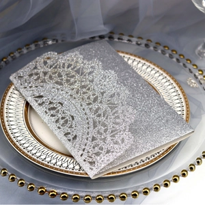 Sparkling silver glitter wedding invitation with laser-cut lace details on gray tulle
