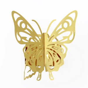 Macro detail of laser-cut gold butterfly napkin ring with hollowed floral patterns