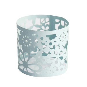 Macro view of laser-cut floral patterns on light blue pearlescent paper napkin rings