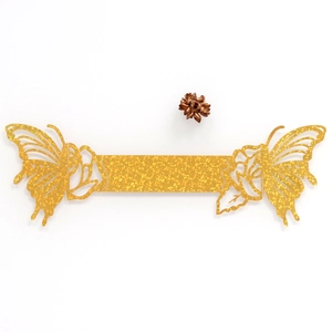 Macro view of gold glitter butterfly and rose laser-cut napkin ring for wedding decor