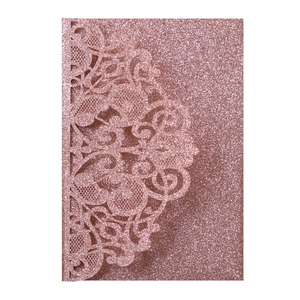 Macro view of rose gold glitter laser-cut wedding invitation sleeve with floral lace