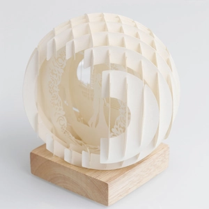 Elegant 3D paper-cut sphere night light with couple silhouette and natural wood base