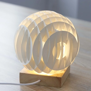 Detailed view of the 3D spherical lamp with layered white petals on a wooden base