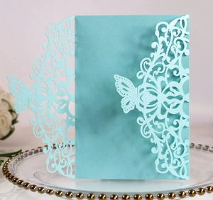 Detail of laser-cut butterfly invitation card with pearlescent finish in soft teal blue