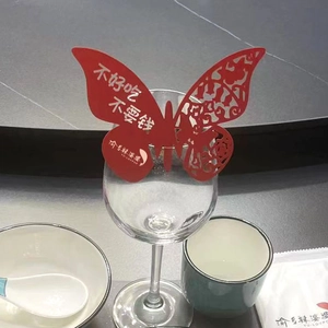 Detail of red hollow butterfly paper card with laser cut design on wine glass rim