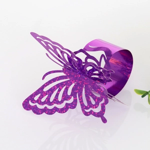 Detail of purple laser-cut butterfly napkin ring with glitter accents for weddings