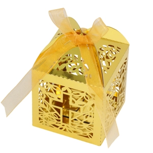 Detail of laser-cut cross pattern on gold candy box with a satin ribbon bow