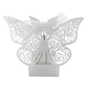 Macro detail of laser-cut white butterfly candy box with rose patterns and ribbon bow