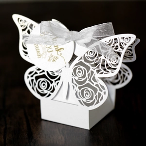 Detail of white laser-cut butterfly gift box with rose pattern and thank you tag