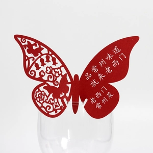 Detailed close-up of a red butterfly glass card with laser-cut patterns on the rim