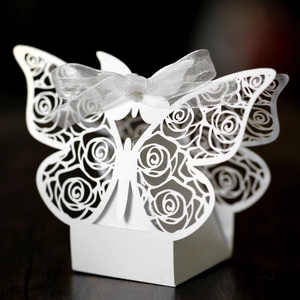 Macro view of white laser-cut butterfly gift box with rose patterns and ribbon decoration