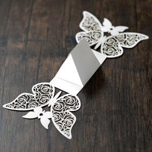 Detailed laser-cut white butterfly candy box with elegant hollow rose patterns on wood