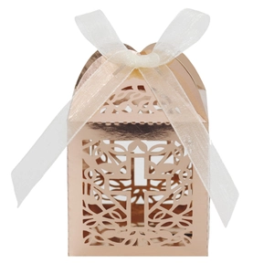 Close-up of laser-cut hollow cross candy box with rose gold finish and ribbon bow
