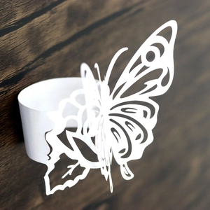 Detail of laser-cut 3D butterfly napkin ring on elegant dark wood background texture