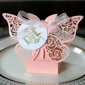 Detail of pink butterfly laser-cut gift box with floral patterns and thank you tag