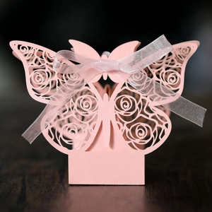 Detailed close-up of pink laser-cut hollow butterfly gift box with white ribbon bow