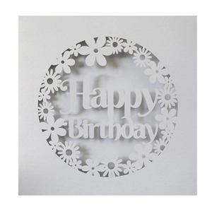 Detail of laser-cut white card featuring delicate daisy patterns and Happy Birthday text