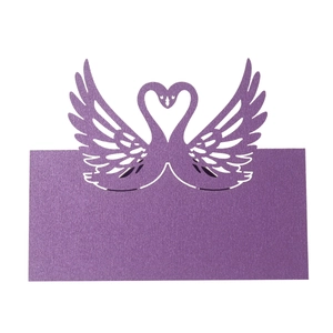Detail of laser-cut purple pearlescent paper table card featuring two swans in heart shape