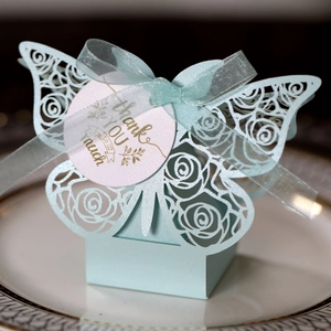 Detail of light blue laser-cut butterfly gift box with Thank You tag on a plate