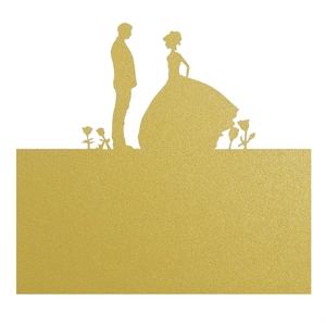 Macro detail of gold glitter wedding place card featuring a bride and groom silhouette