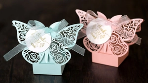 Detailed laser-cut rose hollow butterfly favor boxes in pink and blue with thank you tags
