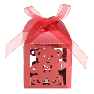 Vista macro di scatola regalo rossa metallizzata con orsetto traforato e nastro organza