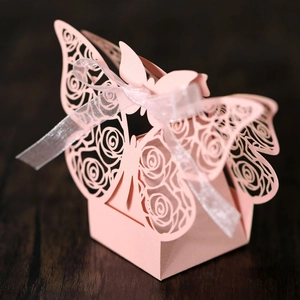 Close-up of laser-cut pink butterfly gift box with rose patterns and ribbon bow