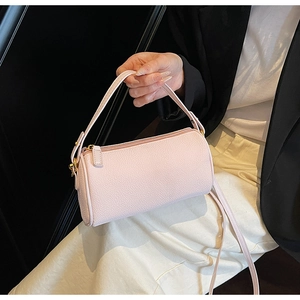 Detail of light pink pebble leather cylindrical shoulder bag with gold-tone hardware
