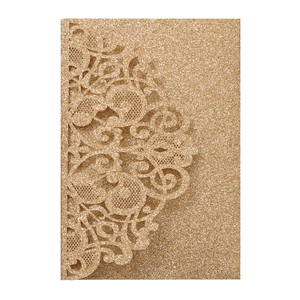 Macro detail of laser cut lace patterns on a gold glitter wedding invitation card