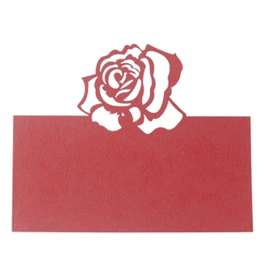 Macro shot of laser-cut red rose name place card with hollow pattern for wedding tables