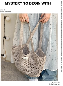 Vue détaillée du sac cabas en paille tissée avec un écusson en tissu blanc marqué ouur