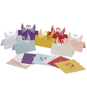 Detail of laser-cut swan place cards in various pearlescent colors for wedding tables