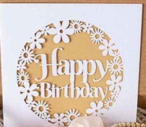 Close-up of laser-cut Happy Birthday card with hollow floral design in a gift box