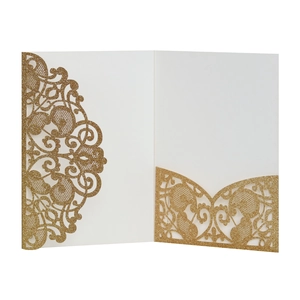 Macro detail of laser-cut floral pattern on golden glitter wedding invitation sleeve