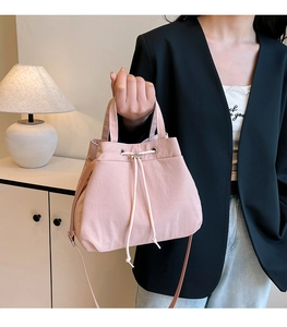 Close-up of pink nylon bucket bag with drawstring closure and silver metal hardware details
