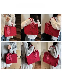 Macro detail of red floral jacquard tote bag with ribbon bow decoration on model