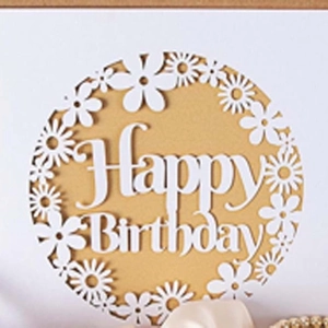 Macro detail of laser-cut Happy Birthday card with intricate white daisy paper patterns