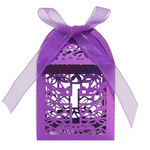 Macro detail of laser-cut cross pattern on purple metallic hollow candy gift box with ribbon