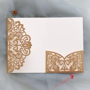 Detail of laser-cut lace pattern on gold glitter wedding invitation sleeve and pocket