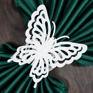Detailed close-up of white laser-cut butterfly napkin ring with intricate hollow pattern