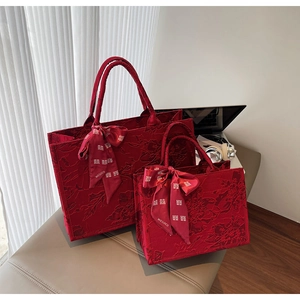 Detail of red floral jacquard tote bags with festive ribbon and Chinese wedding motifs