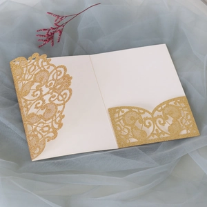 Macro shot of laser-cut gold glitter wedding invitation cover with intricate baroque patterns