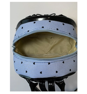 Détail du mini sac à dos rayé avec motifs de cœur et ouverture zippée fluide