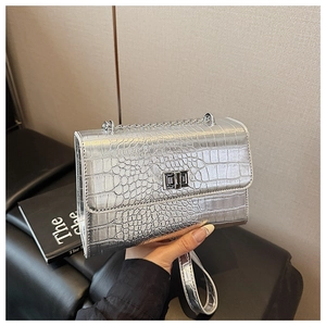 Detail of silver crocodile pattern shoulder bag with metal chain and square twist lock