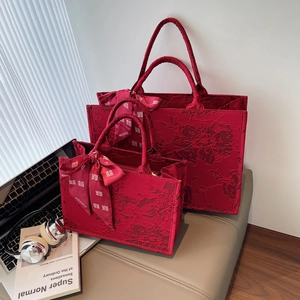 Detail of red wedding tote bags with floral texture and silk scarf with Xi character