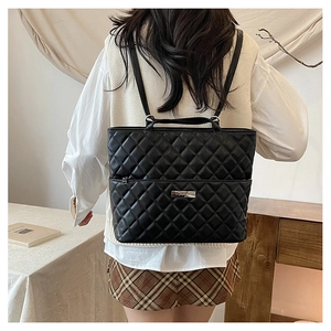 Rear view of black quilted diamond backpack worn with casual stylish outfit